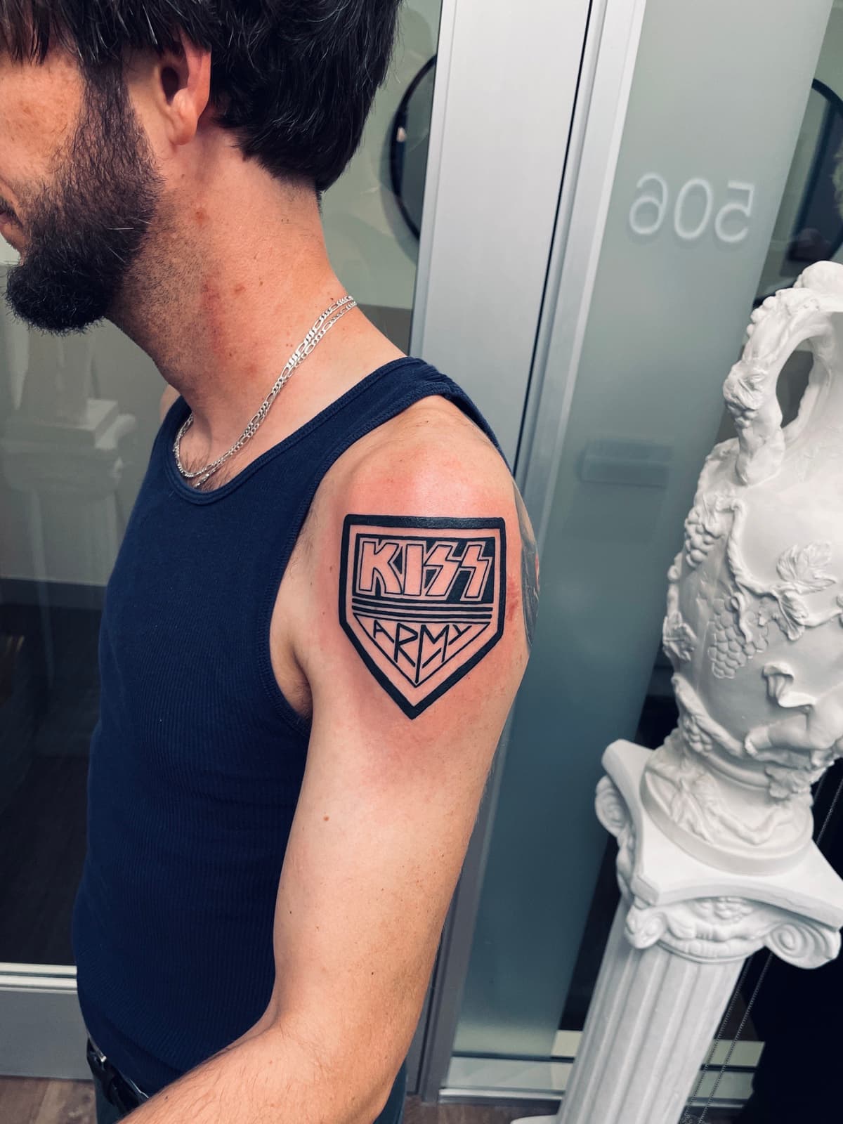 Blackwork tattoo KISS Army shield logo on upper arm in Los Angeles