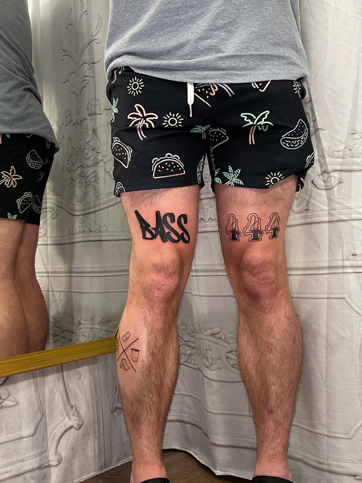 Blackwork tattoo bold BASS lettering on knee in Los Angeles