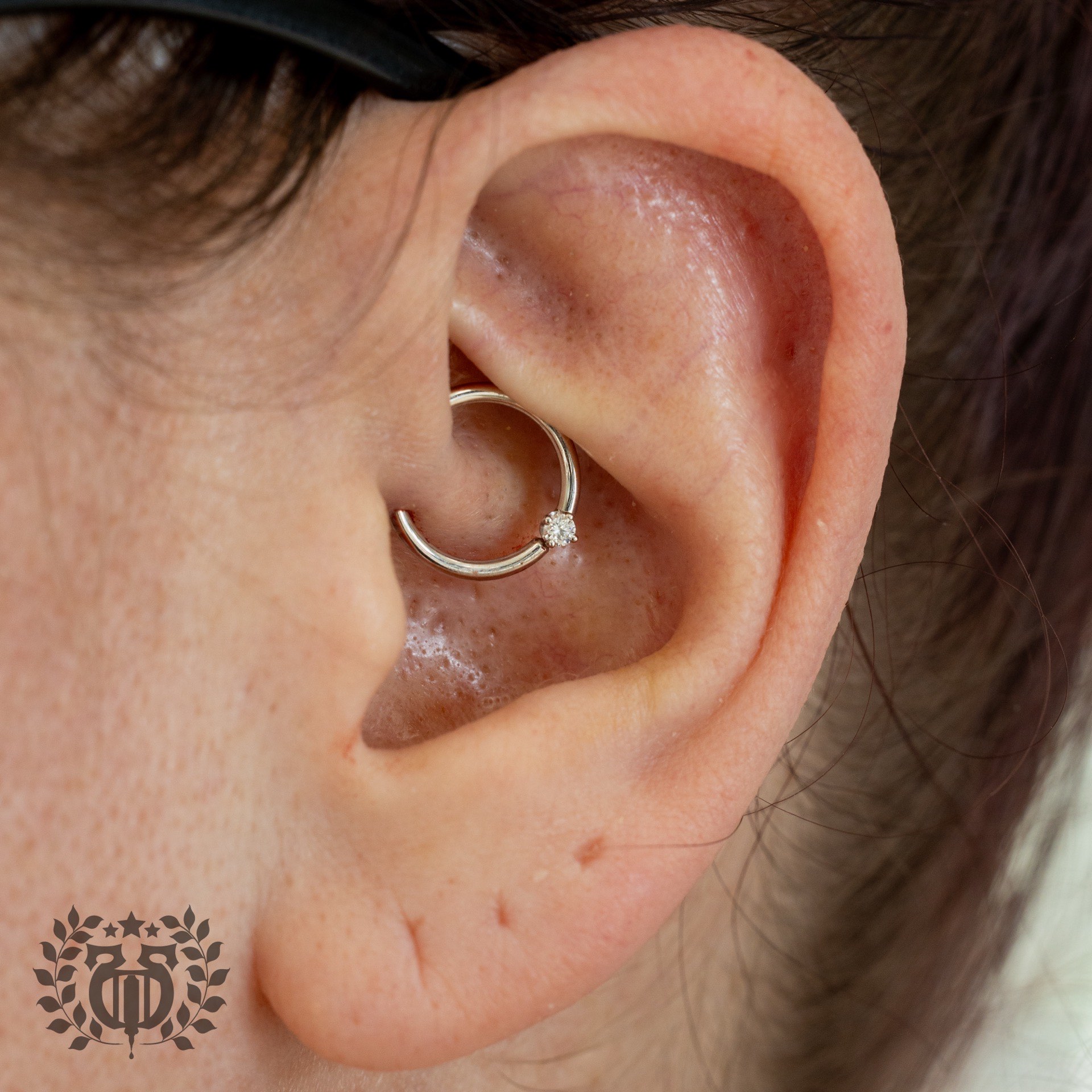 Silver hoop daith piercing with single CZ gemstone at Apollo Studio Los Angeles