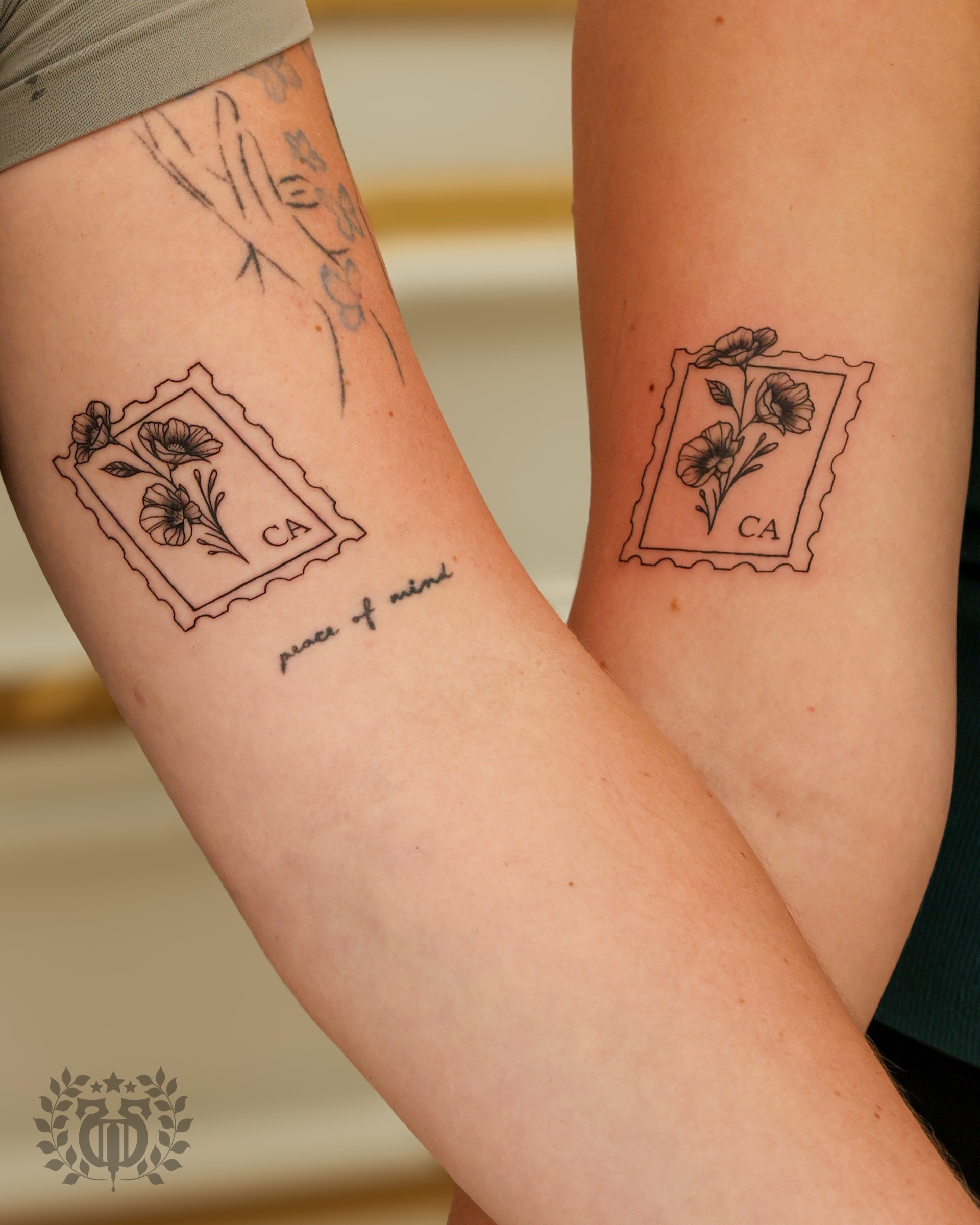 Matching California poppy stamp tattoos by fine line tattoo artist in Los Angeles