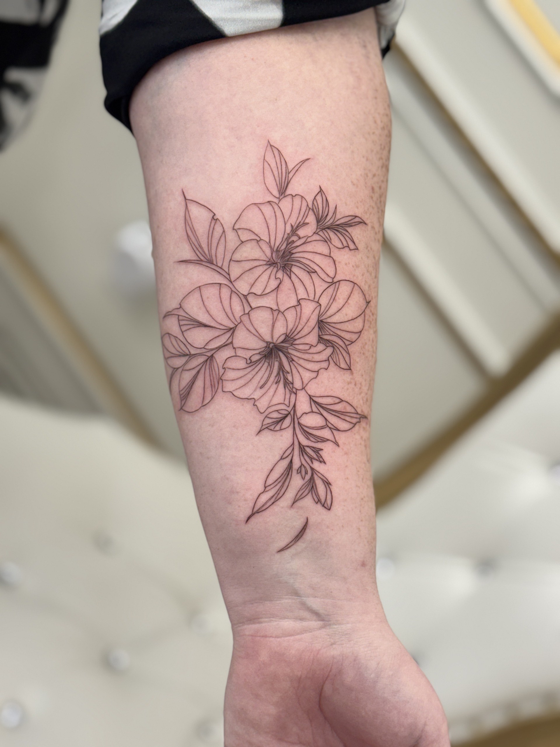 Floral bouquet with leaves tattoo by fine line tattoo artist in Los Angeles