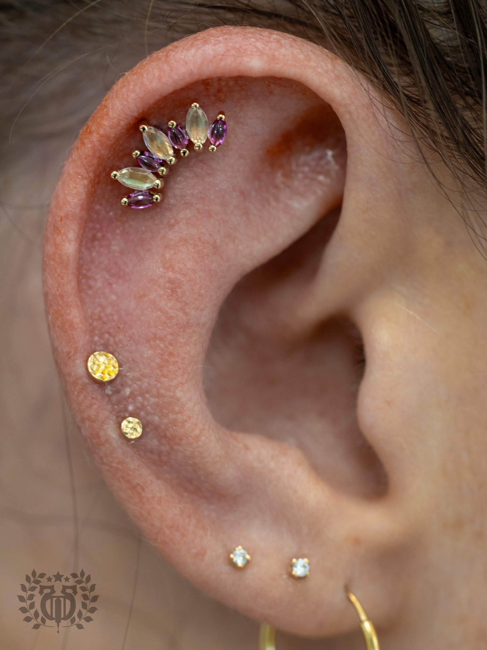 Gold opal and amethyst marquise ear cartilage cluster with gold bezel lobe studs at Apollo Studio