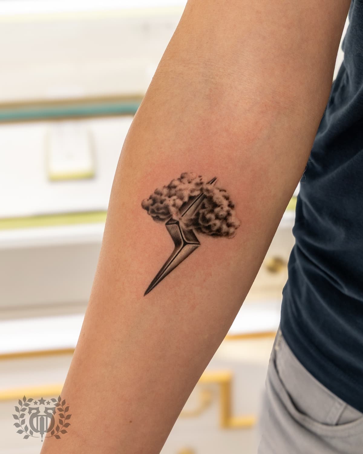 Black and grey realistic star with smoke cloud realism tattoo on forearm in Los Angeles