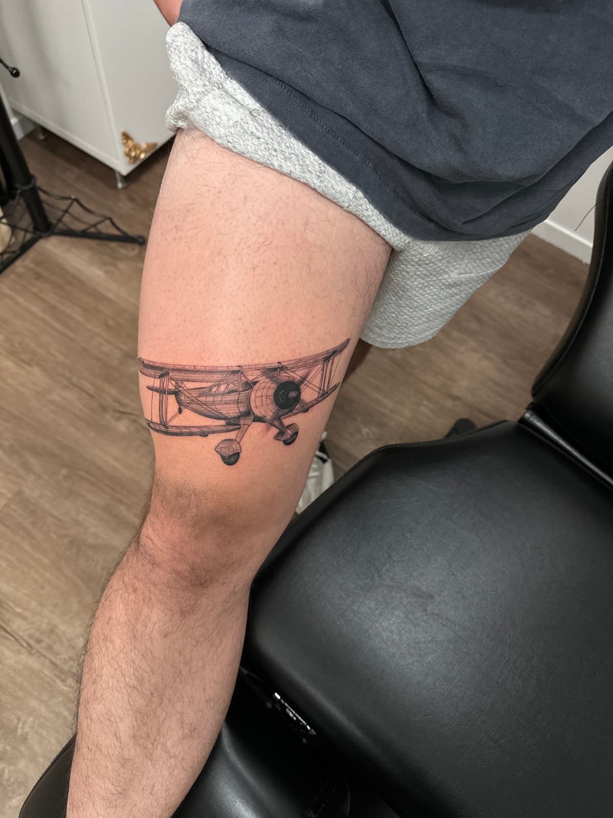 Black and grey realistic vintage biplane realism tattoo on thigh in Los Angeles