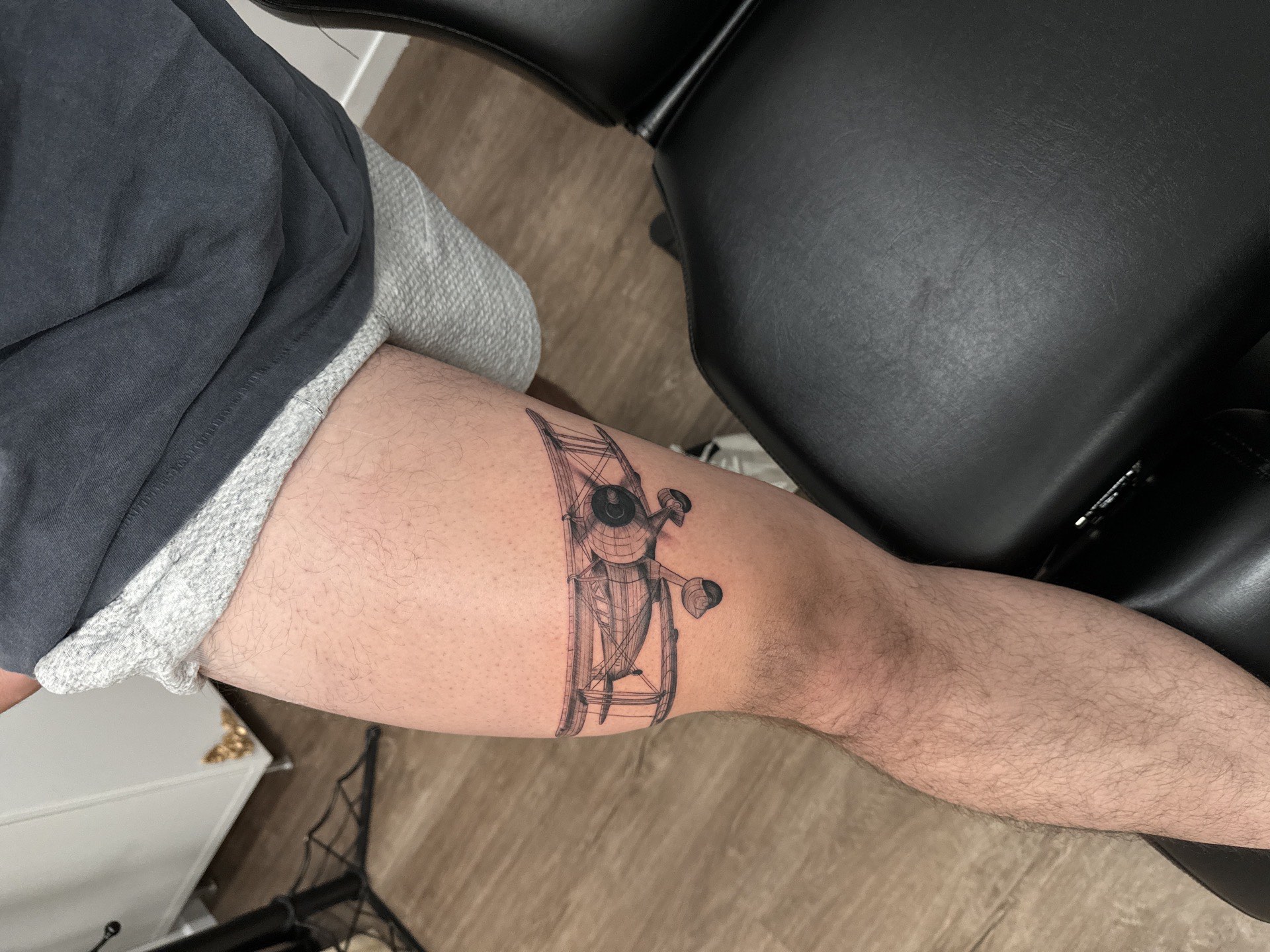 Black and grey realistic vintage biplane realism tattoo on thigh in Los Angeles