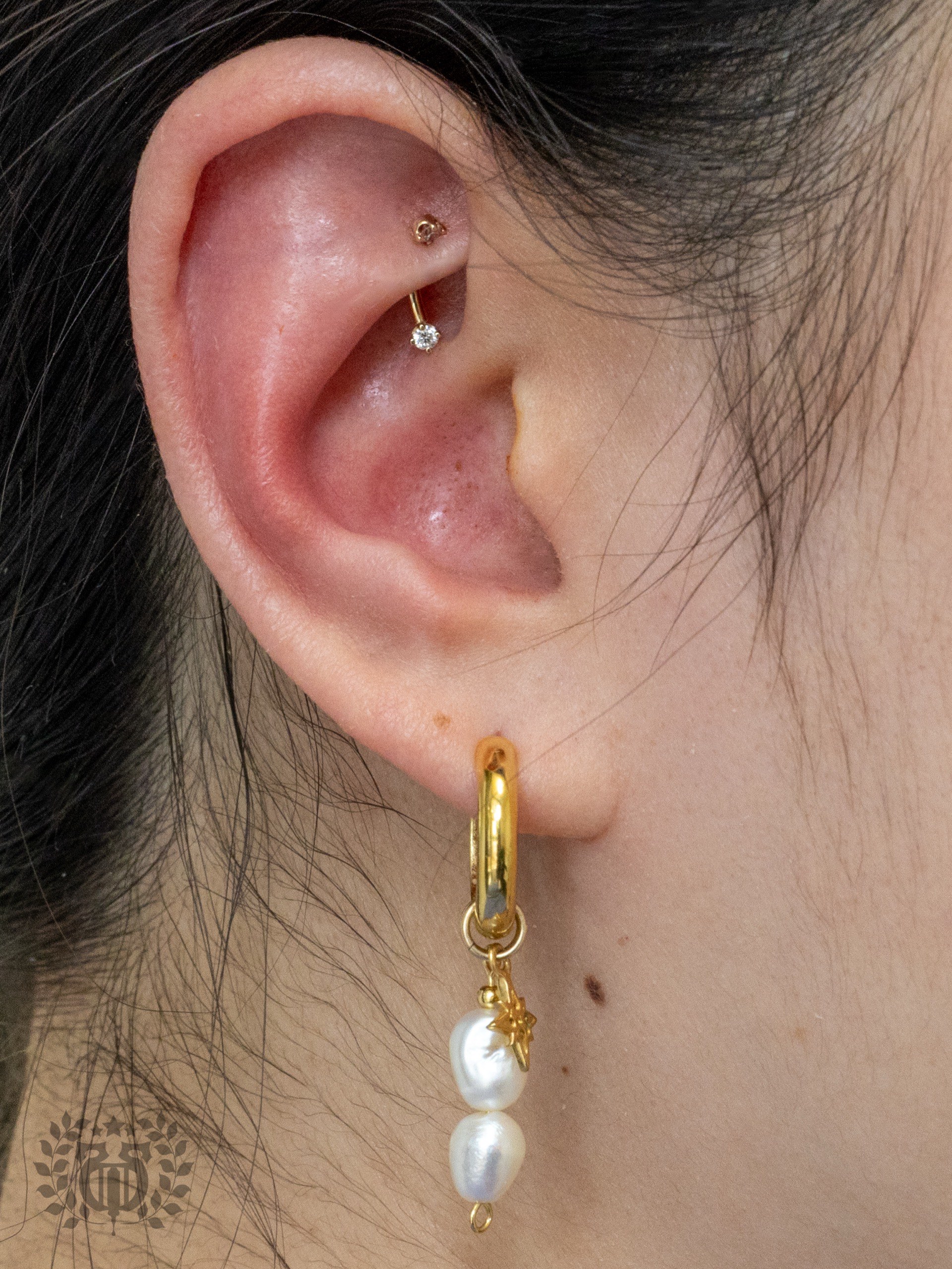 Rook piercing with CZ curved barbell and gold pearl dangle lobe hoop at Apollo Studio LA