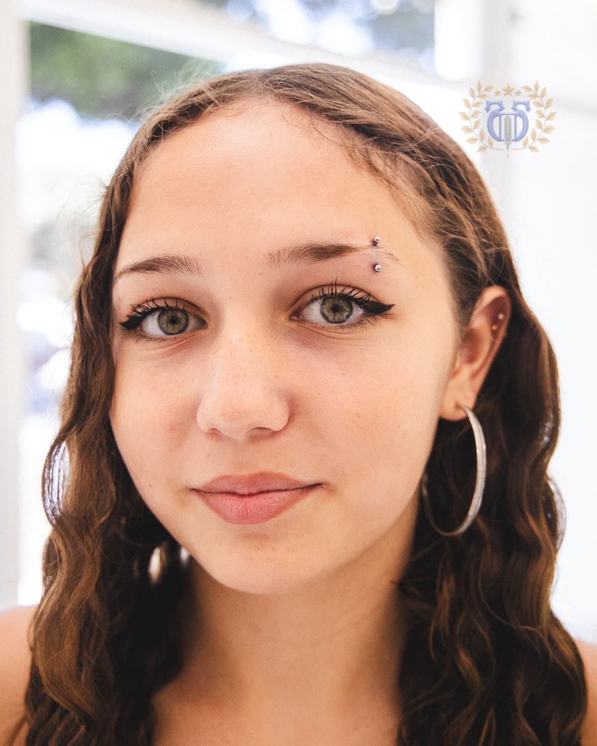 Small silver eyebrow piercing portrait at Apollo Tattoo and Piercing Studio