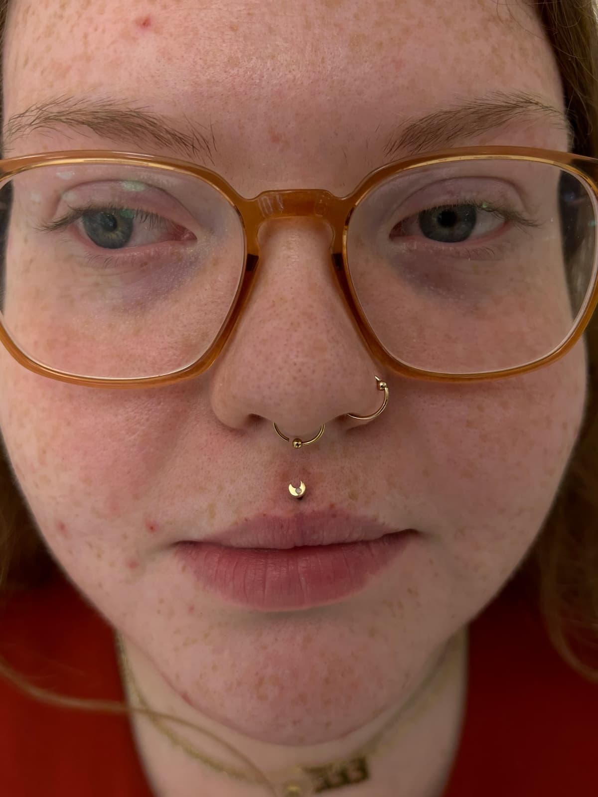 Labret piercing with tiny silver prong-set CZ stud below lower lip at Apollo LA