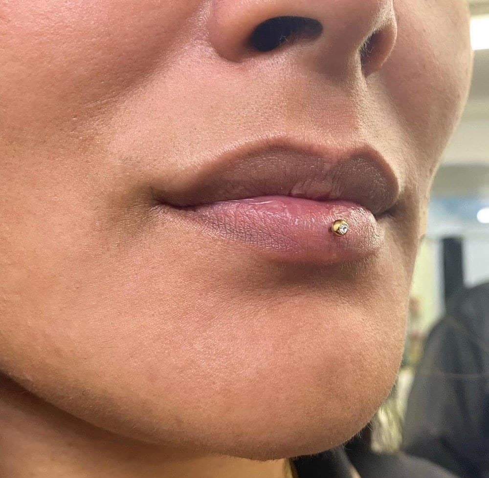 Snake bites double lower lip piercing with silver flat-head studs at Apollo Studio Los Angeles