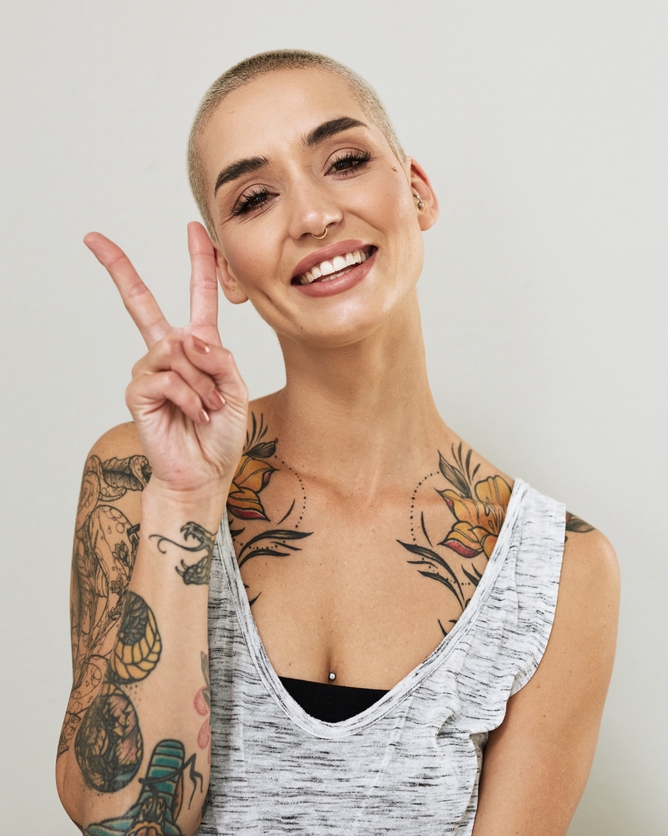 tattoo pierced woman giving peace sign